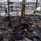 Los niños pasan junto a un aula destruida.