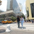 Un para de personas atraviesa una calle de Guayaquil en un día de mucho sol.