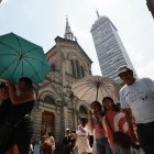 Varias personas caminan con sombrilla para protegerse del sol, este jueves en Ciudad de México (México).