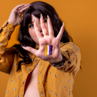 Persona mostrando la bandera del género no binario.