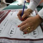 Una mujer iraní rellena la papeleta de voto en un colegio electoral durante las elecciones presidenciales, en Teherán, Irán, el 28 de junio de 2024.