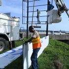 Personas desmontan un anuncio ante la inminente llegada del huracán Beryl este 2 de julio de 2024, en Kingston.