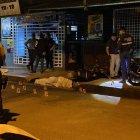 Policías y curiosos observan el lugar donde ocurrió el crimen.