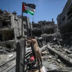 Gaza. Un hombre coloca una bandera palestina en medio de edificios destruidos tras un ataque aéreo israelí.