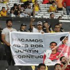 Hinchas con un cartel que prometieron llevar en los demás partidos en homenaje a Justin Cornejo.