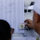 Un ciudadano venezolano busca su mesa de votación durante la jornada de elecciones presidenciales de Venezuela este domingo, en Caracas (Venezuela).