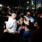 Seguidores del presidente de Venezuela y candidato a la reelección, Nicolás Maduro, bloquean el acceso a personas que intentan entrar a un centro de votación en Caracas.