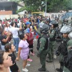 Personas reclaman frente a integrantes de la Guardia Nacional Bolivariana (GNB) durante una manifestación luego de los resultados de las elecciones presidenciales este lunes, en el sector del Primero de Mayo en Caracas (Venezuela).