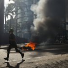 Un manifestante corre durante enfrentamientos entre opositores y miembros de la Guardia Nacional Bolivariana (GNB).