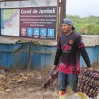 Labor. Un cangrejero sostiene dos atados de cangrejos rojos.