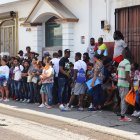 Migrantes hacen fila a la esperar de resolver su situación migratoria este sábado, en la ciudad de Tapachula