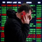 Una persona habla por teléfono frente a los paneles indicadores en la Bolsa de Valores de Australia (ASX) en Sídney, Australia.