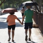 Una pareja pasea protegida por paraguas esta mañana en Madrid.