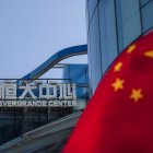 Empresa. Vista de la bandera china junto a la sede de la constructora Evergrande en Shanghai, China este jueves. El gigante inmobiliario chino Evergrande se disparó en bolsa tras anunciar que afrontará el próximo pago de intereses de unos bonos denominados en yuanes, aunque todavía no ha confirmado si hará lo propio con otros denominados en dólares, cuyo plazo también vence este jueves. EFE/ Alex Plavevski