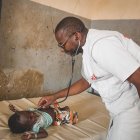 El doctor Baricomo Karambé, médico clínico, se encuentra en medio de una consulta con un niño desplazado.