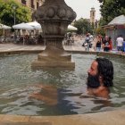 Granada. Un hombre se refresca en una fuente de la Plaza Nueva.