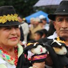Una pareja sosteniendo dos cuy disfrazados de campesinos en Urbina (Ecuador), participando en el cuarto Festival del Cuy de Ecuador, una fiesta en torno al roedor más emblemático de los Andes.