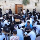 Los judíos ortodoxos rezan mientras leen el libro de Eicha (Libro de Lamentaciones) para conmemorar Tishá B"av, en el Muro de las Lamentaciones, en la Ciudad Vieja de Jerusalén, el 13 de agosto de 2024.