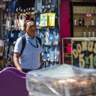 Un hombre junto a pantalones para la venta, en Caracas.