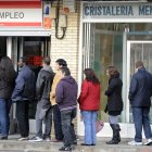 Trabajadores. Una fila de personas que buscan empleo esperan su turno de atención en una oficina en España.