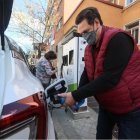 Vehículo.- Una persona pone carga a un carro eléctrico.