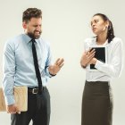 Angry boss. Man and his secretary standing at office or studio. Business man with his colleague. Female and male caucasian models. Office relationships concept, Human emotions