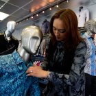 Comercio. Una trabajadora arregla una camisa en un maniquí, en una tienda de Estados Unidos.