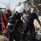 Equipos de rescate trabajan en el lugar donde cayó un proyectil ruso este lunes 26 de agosto, en una de las avenidas de la ciudad de Lutsk.