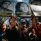 Manifestantes que muestran retratos de víctimas de la dictadura
