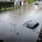 Un coche sumergido en via Pompeo Leoni, tras las fuertes lluvias en Milán, Italia.