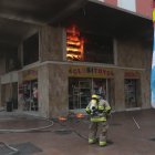 Un bombero intenta sofocar las llamas del interior de un establecimiento en las calles Boyacá y Clemente Ballén, en el centro de Guayaquil.
