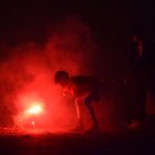 Un niño indio enciende un petardo durante las celebraciones del festival Diwali.