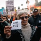 Una mujer que sostiene un cartel en una manifestación de jubilados el 28 de agosto de 2024