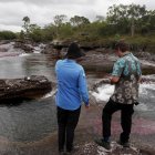 Dos personas observan el río Caño Cristales, también llamado el "río de los siete colores", en zona rural de La Macarena, departamento del Meta (Colombia).