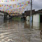 Archivo. Un niño camina por una calle inundada en Cali como consecuencia del fenómeno climatológico de "La Niña".