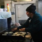 Una mujer hispana trabajando en un local de comida.
