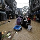 Unas personas en una barca cargada con una motocicleta a través de las aguas inundadas, en Hanoi, Vietnam, este miércoles.