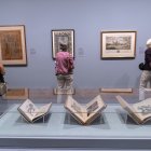 Personas observan unos carteles durante la exposición "Grabados mexicanos a la vanguardia".