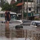 Hombres tailandeses observan una calle inundada tras fuertes lluvias en zonas urbanas de la provincia de Chiang Rai, al norte de Tailandia, el 12 de septiembre de 2024.