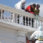 Agentes de la Policía y socorristas de los Bomberos de Cayambe trabajaron para rescatar al hombre que las personas dejaron suspendido en el atril del edificio del Municipio de Cayambe.