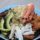 Boliniche. Es un bolón de verde con maní, bañado en una salsa velouté, acompañado de un ceviche de pescado o concha, con camarones apanados, con calamares y aguacate.