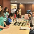 Martha Fierro (der) haciendo lo que más le gusta, enseñando ajedrez.