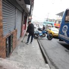 impieza. Vecinos limpiaban los vidrios rotos de la peluquería que quedaron esparcidos por la calle tras el violento ataque armado.