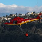 Fotografía de un helicóptero de bomberos lanzando agua para extinguir un incendio el 12 de septiembre de 2024 en las laderas del cerro El Panecillo, ubicado en el centro Histórico de Quito (Ecuador).