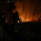 Vecinos de la avenida González Suárez y Manuel Barreto, en el norte de Quito, ayudan a los bomberos en las tareas de sofocar las llamas, la noche de este martes 24 de septiembre.