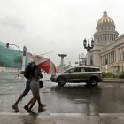Dos personas caminan bajo la lluvia en la Habana.