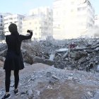 Una mujer toma una foto de un edificio destruido en el barrio de Haret Hreik,