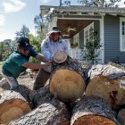 Ángel Sánchez (L) y Miguel García (R) cortaron un pino derribado que dañó una casa después de que el huracán Helene azotó Valdosta, Georgia, EE.UU., el 30 de septiembre de 2024.