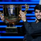 El español Carlos Alcaraz celebra con el trofeo tras vencer en la final del Open de China de Tenis al italiano Jannik Sinner.