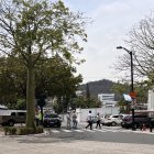 Limpieza. Mientras colocan las banderas en la parte alta de los postes, la líder de la comunidad de Los Ceibos aprovecha para recolectar la basura que está en las calles. La ciudadela siempre luce limpia.